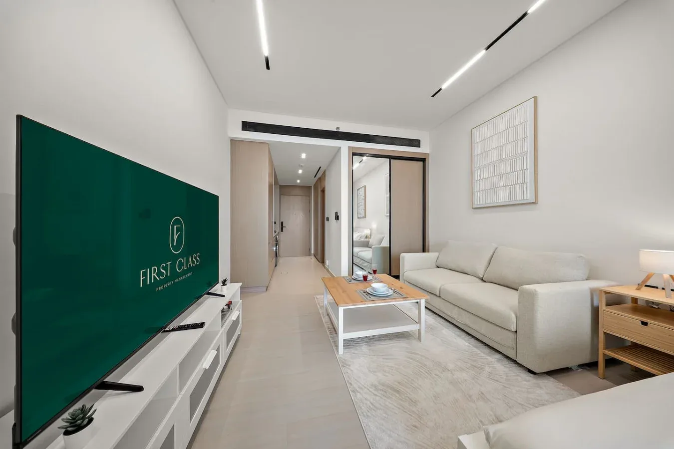 Una sala de estar moderna con sofá, mesa de centro y televisor.