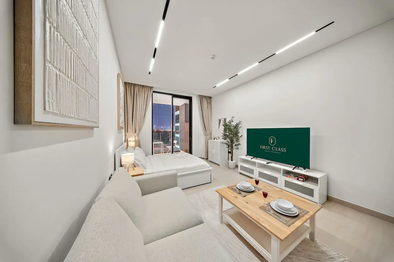 Una sala de estar moderna con asientos, un televisor y una mesa de centro.