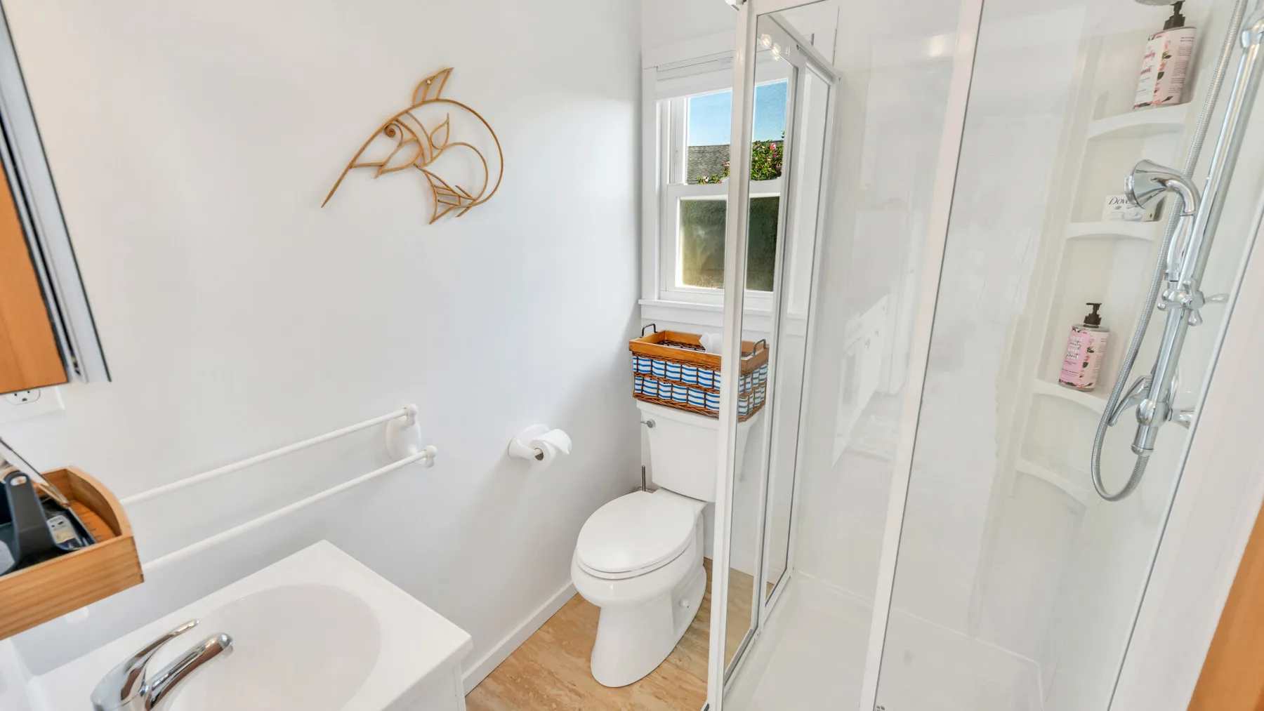 Un baño luminoso con bañera, inodoro y ducha de cristal.