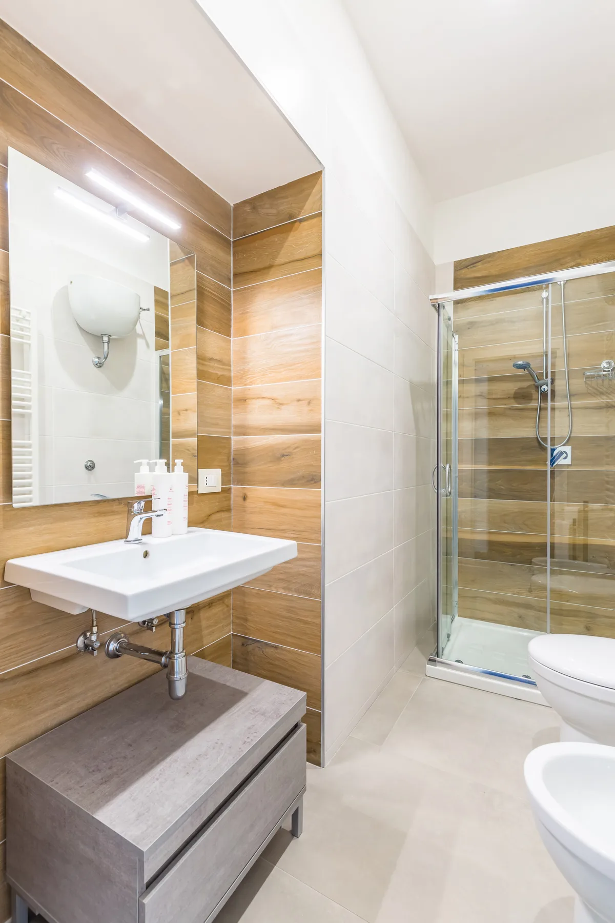 Un baño con lavabo y ducha con mampara de vidrio.