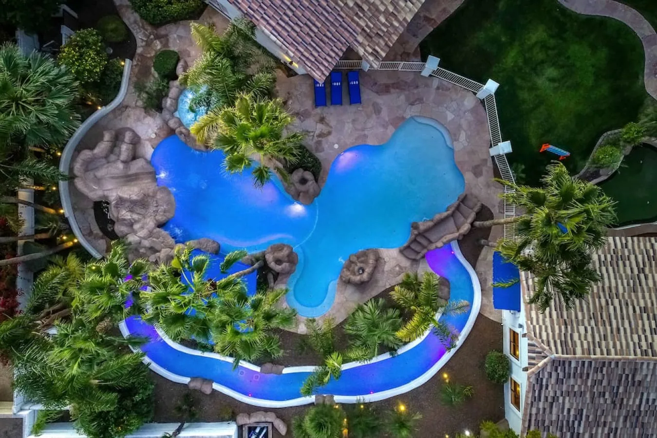 An aerial view of a landscaped swimming pool with curved surrounding paths.