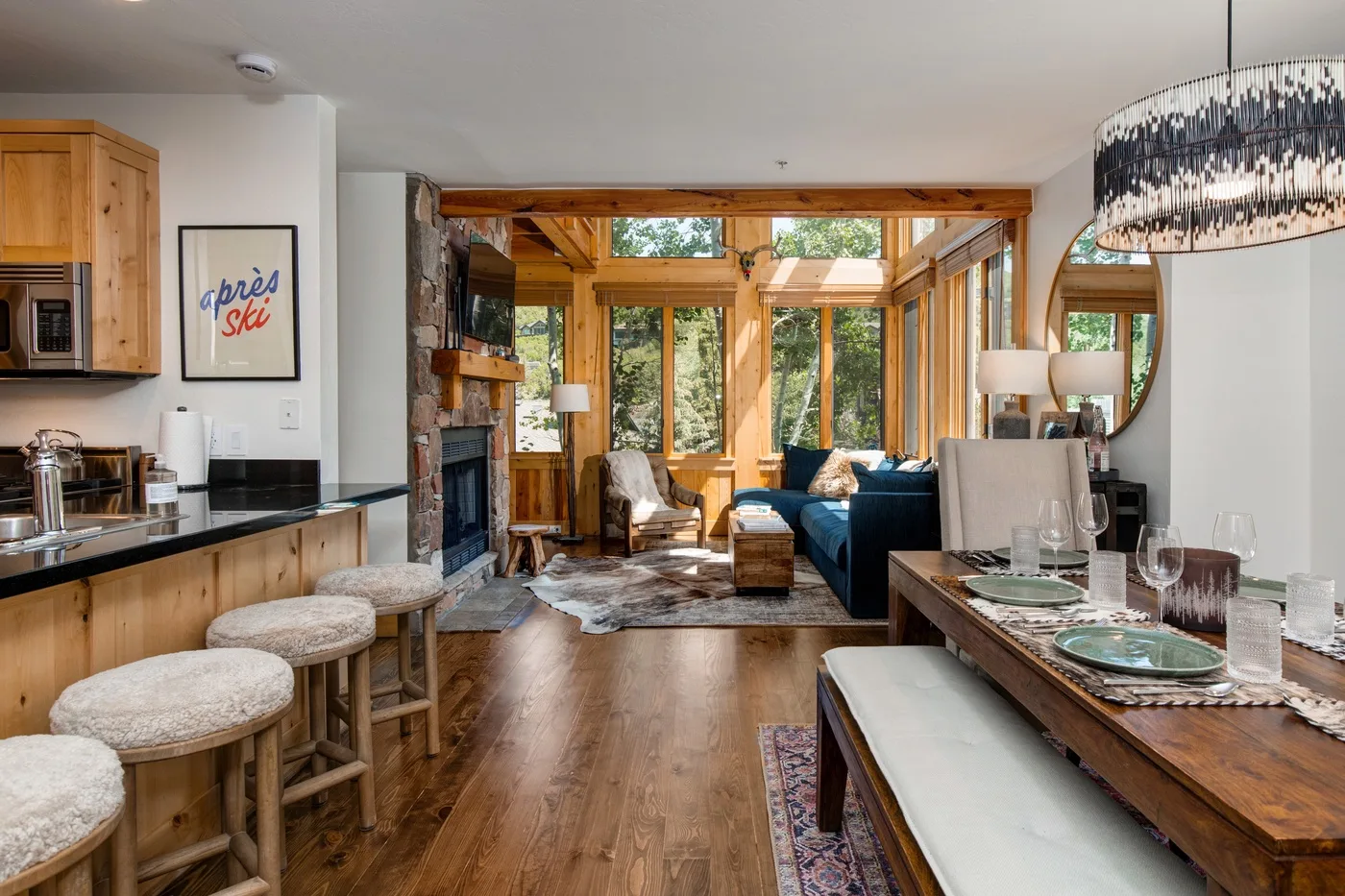 An open-plan living and dining area with a kitchen counter and large windows.