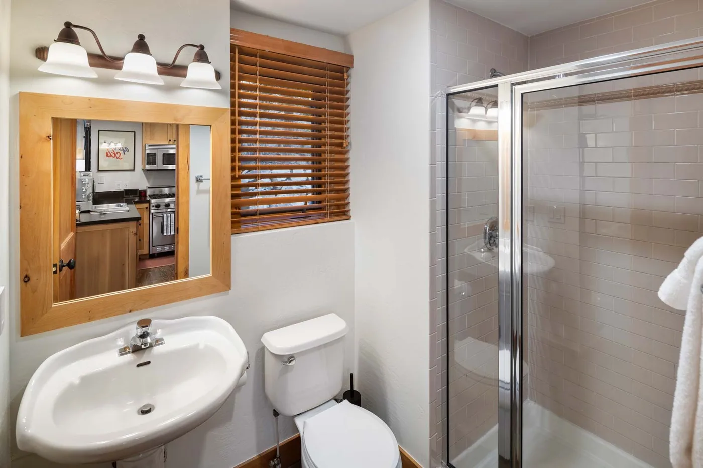 Un baño con lavabo y una ducha con mampara de vidrio.