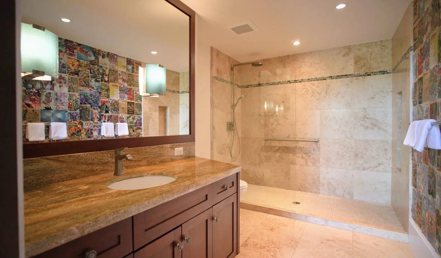 Se ve un lavabo de baño junto a una ducha amplia y azulejos coloridos.