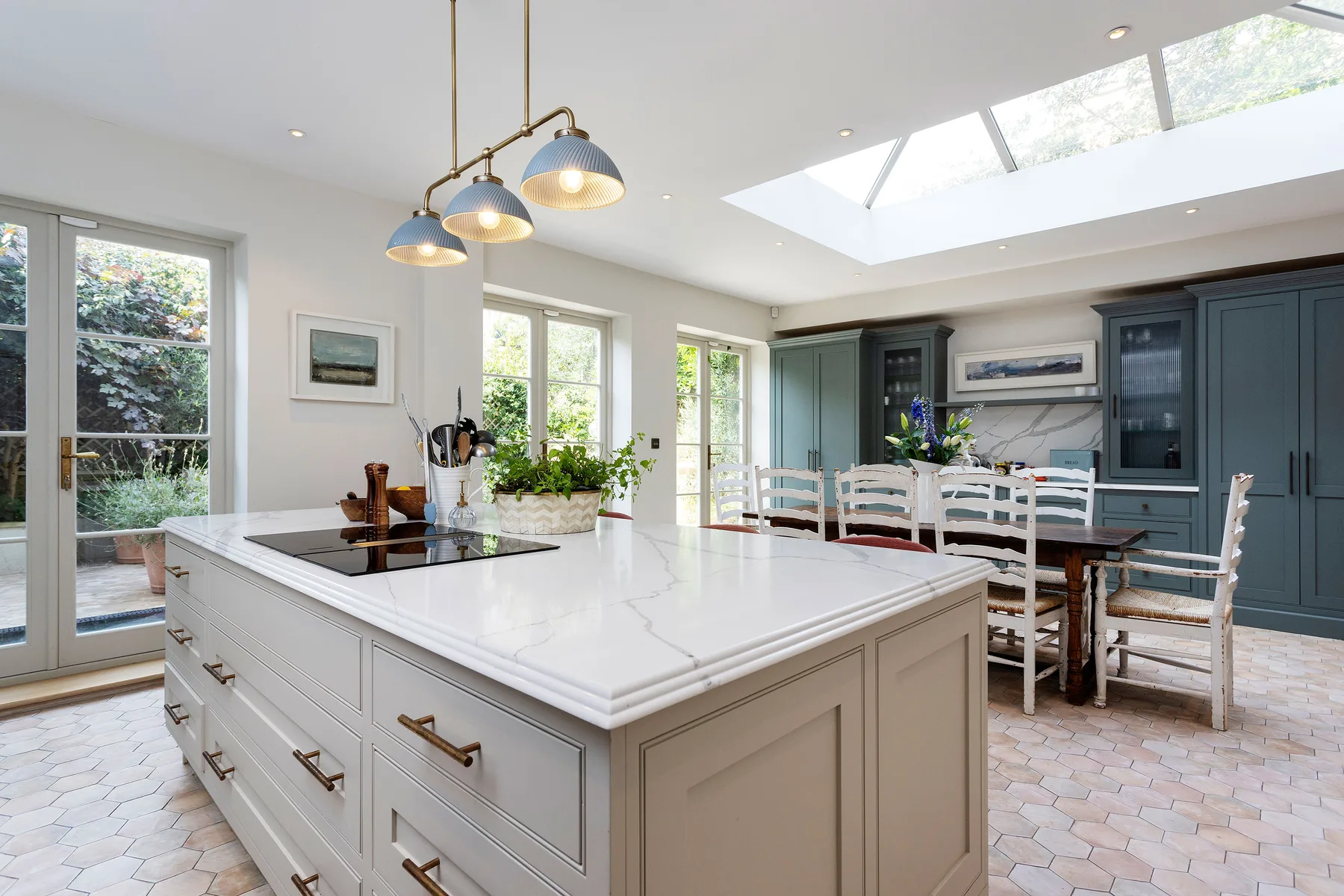 A bright kitchen and dining area with a large island and skylight.