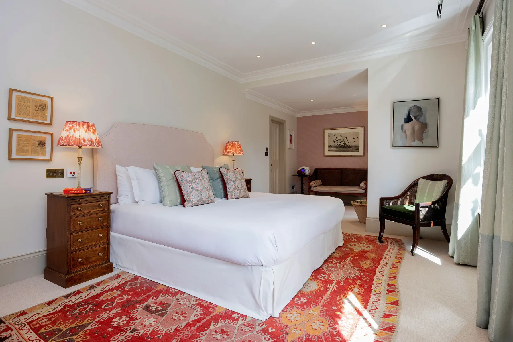 Un dormitorio luminoso con una cama grande y una alfombra estampada.