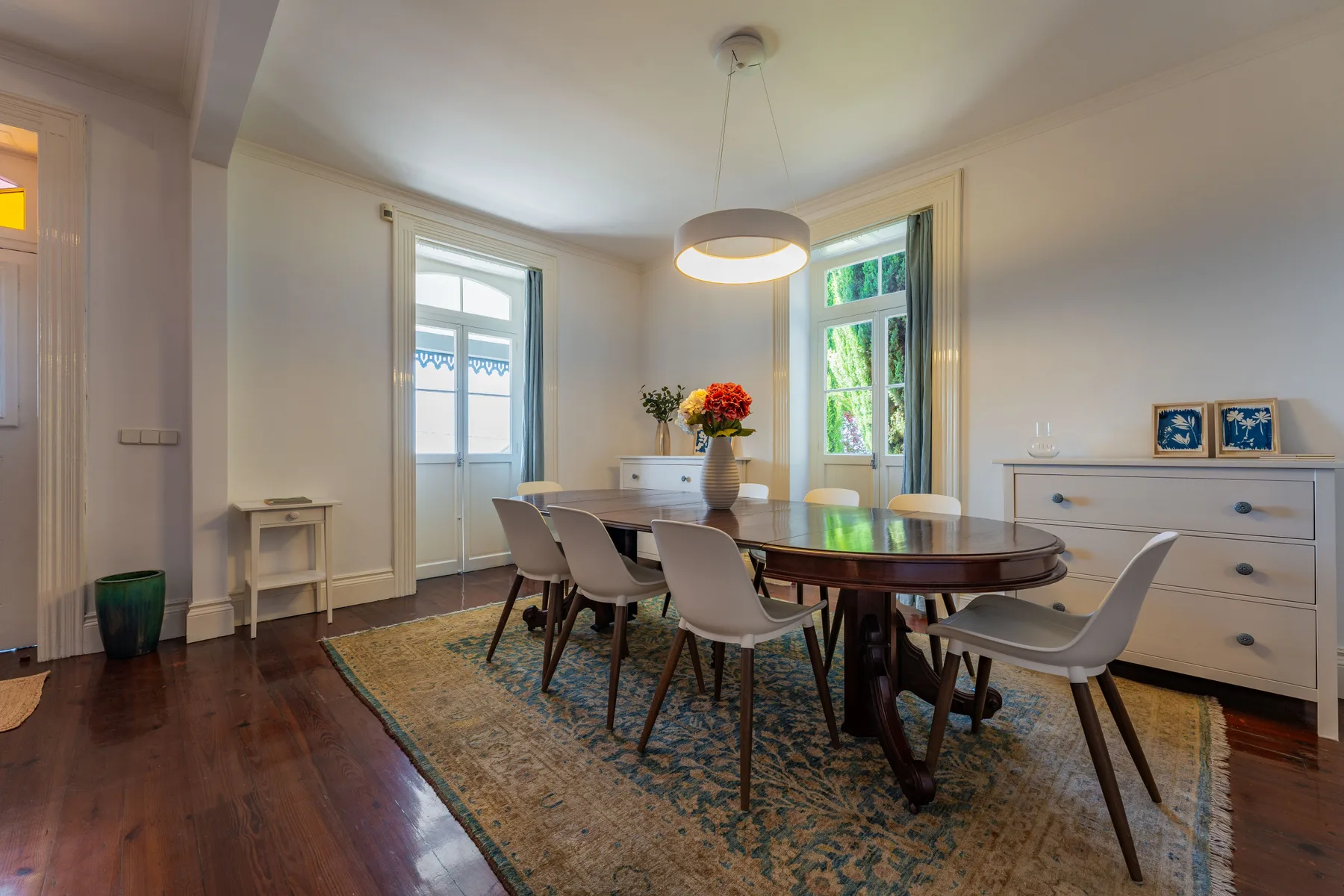 Comedor con una mesa de madera, sillas y una alfombra.