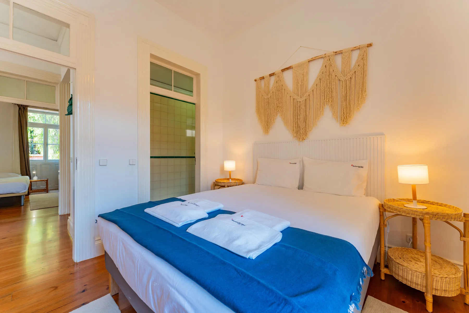 Un dormitorio con una cama bien hecha y mesitas de noche.