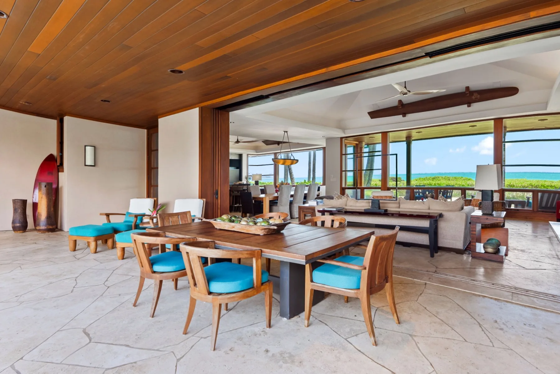 Una sala-comedor de planta abierta con asientos de madera y ventanas amplias.