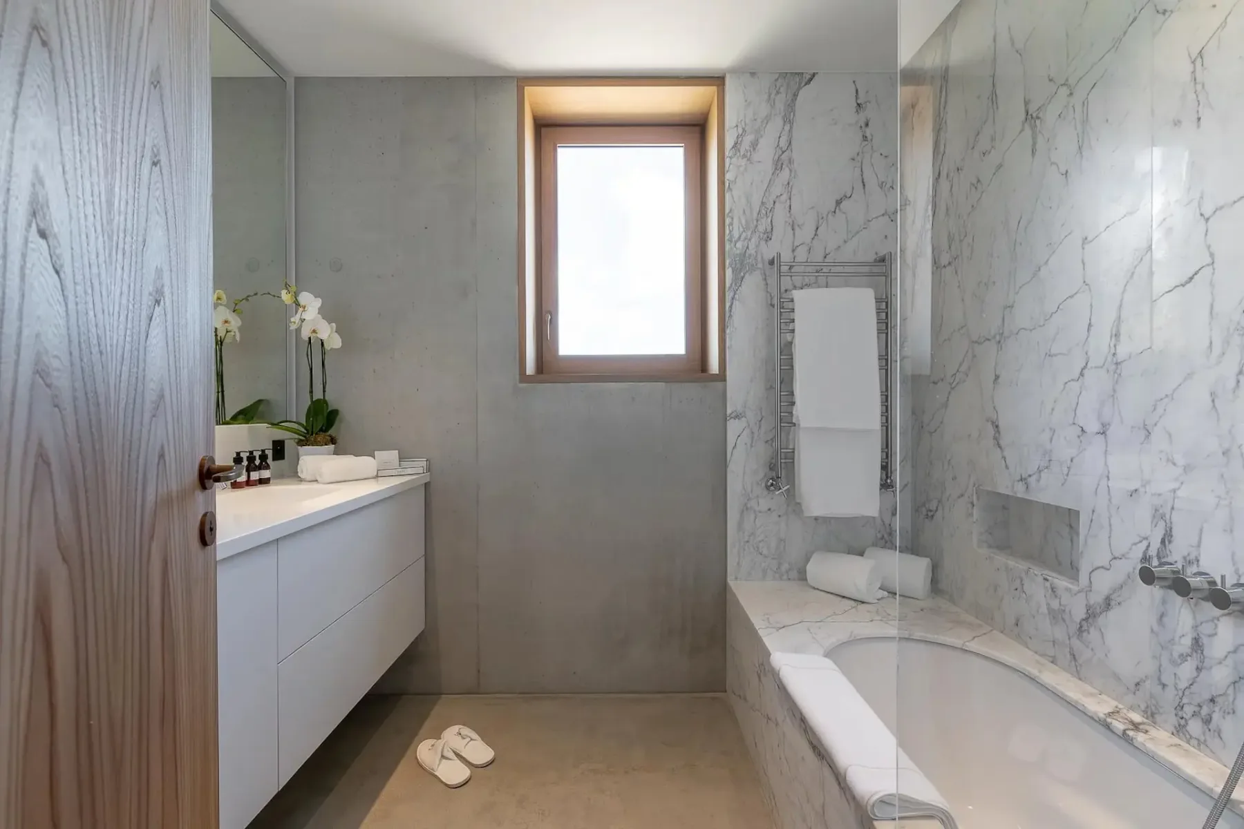 Un baño con bañera, lavabo y ventana.