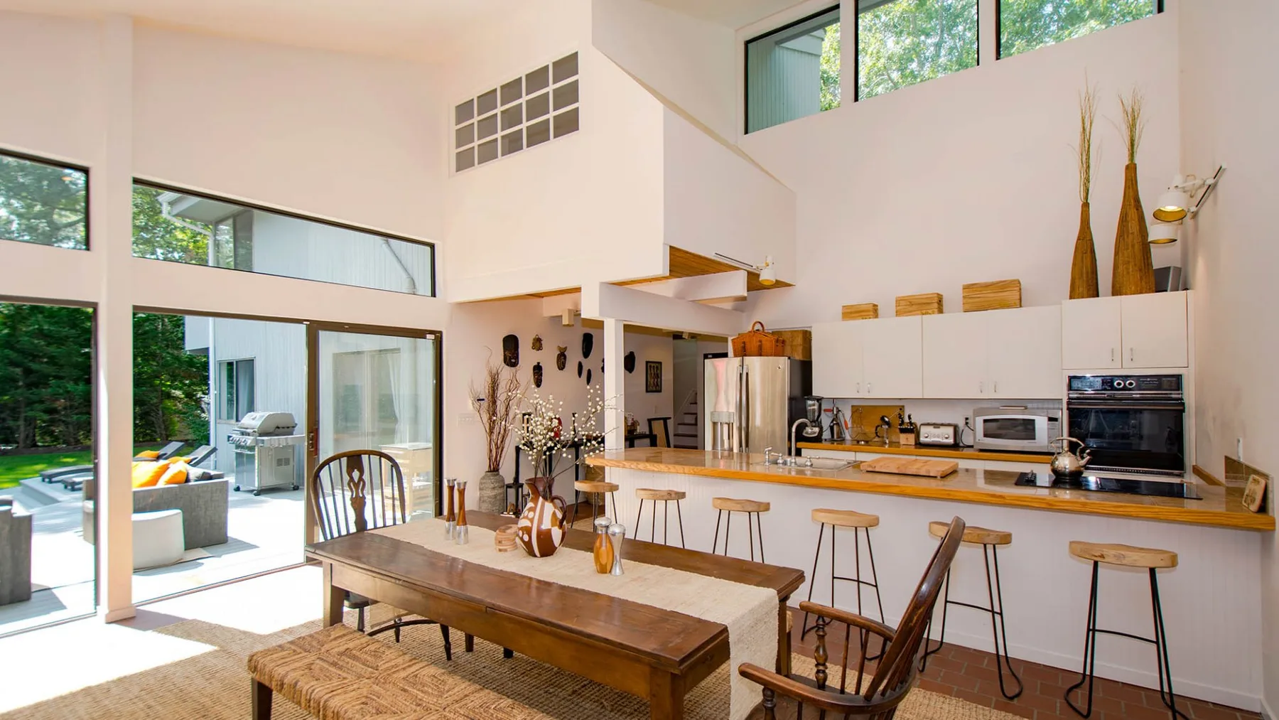 A bright open-plan kitchen and dining area has a long table and counter seating.