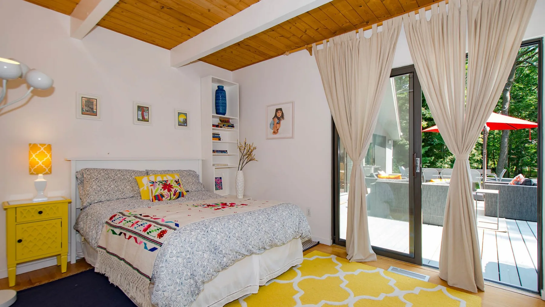 A bedroom with a bed beside glass doors opening onto a patio.