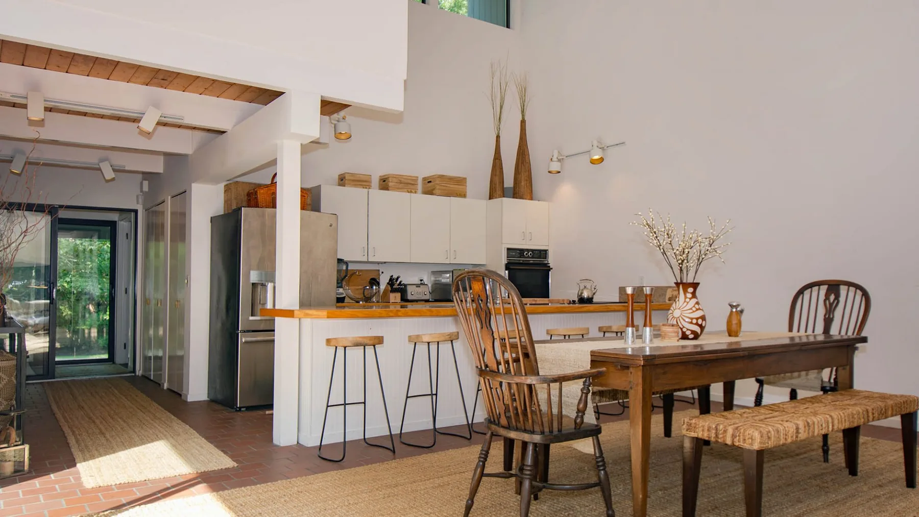 An open kitchen and dining area with a wooden table and counter seating.