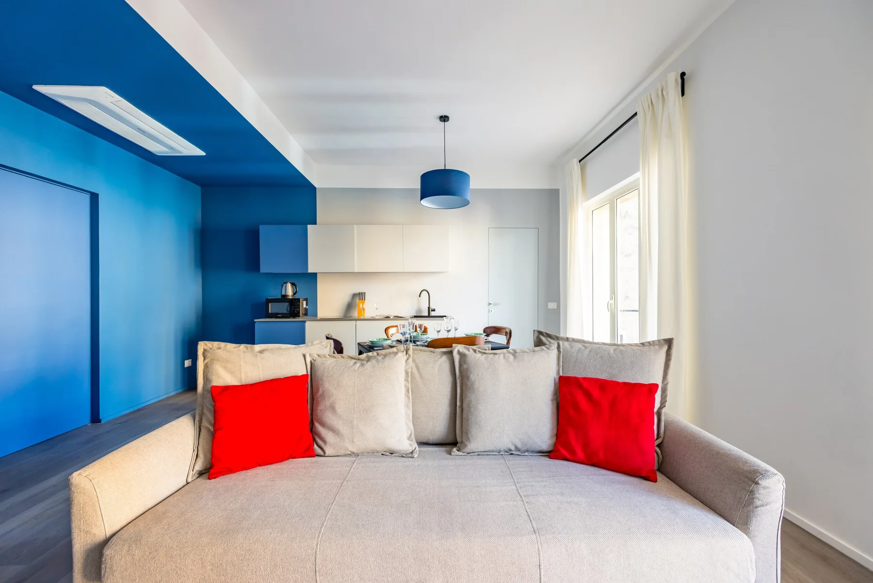A living area with a gray sofa and a blue accent wall.