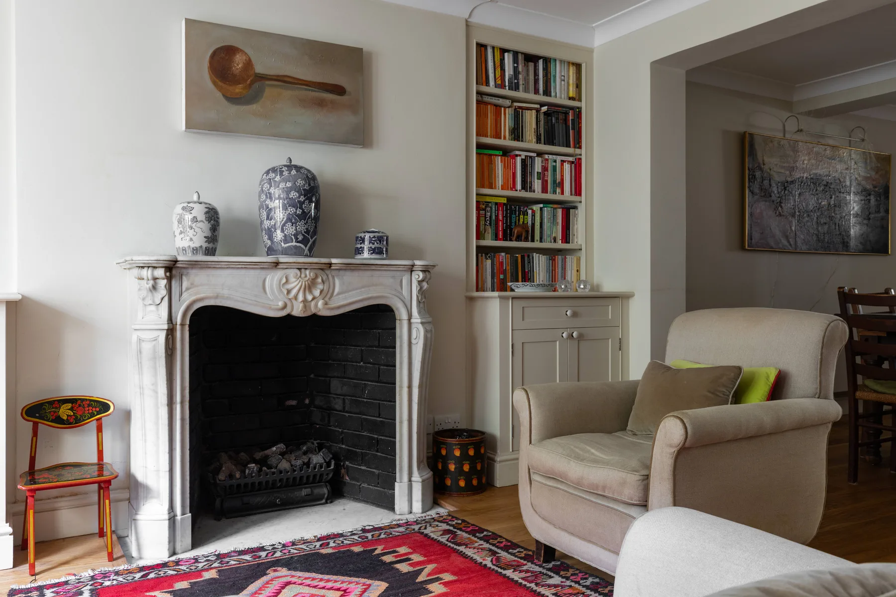 A living room with a fireplace, built-in bookshelves, and upholstered seating.