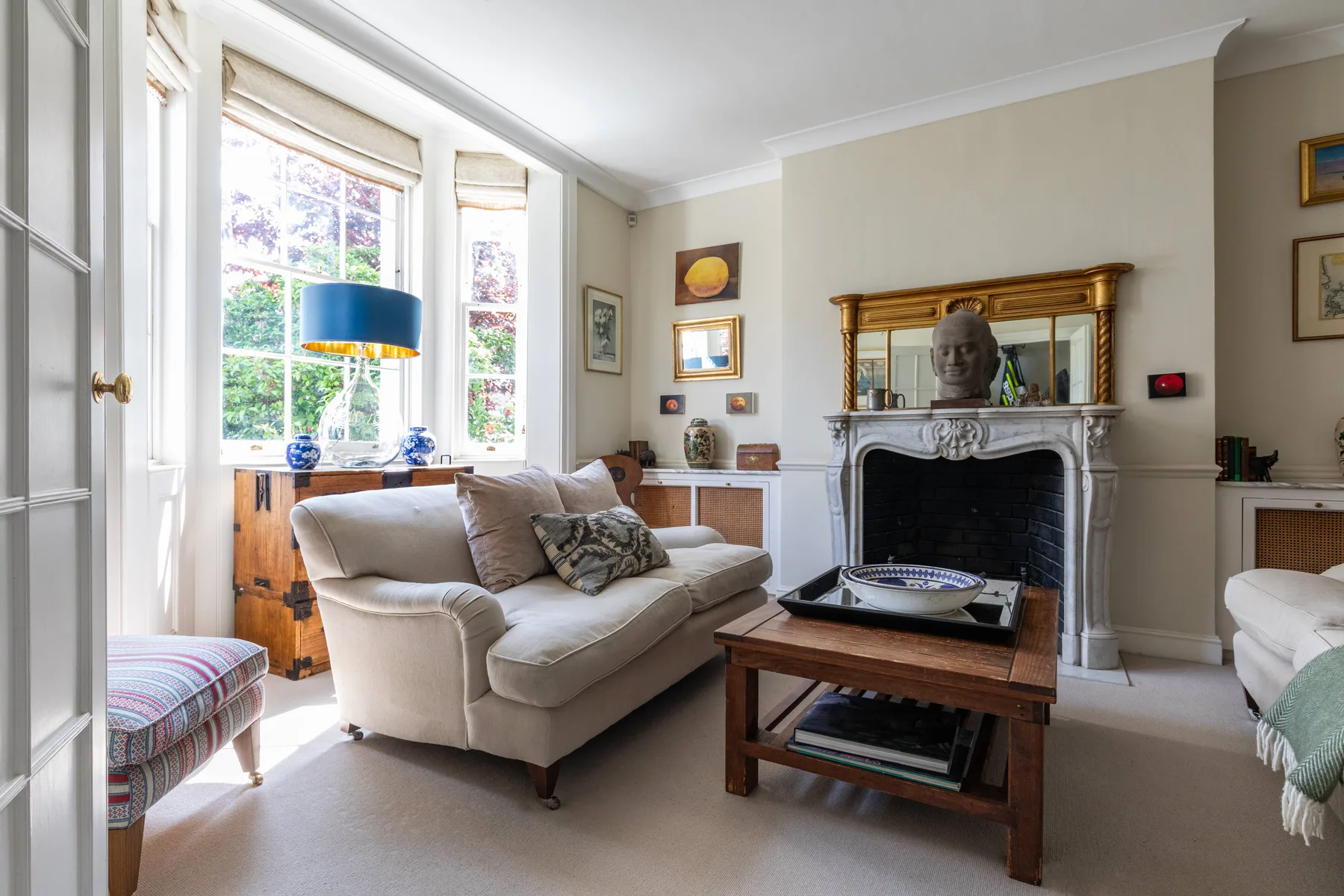 A bright living room with seating arranged around a fireplace and coffee table.