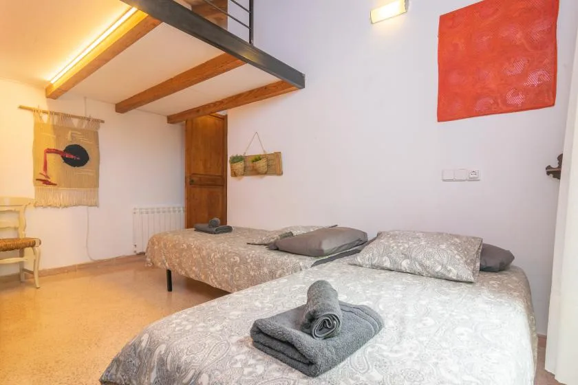 A bedroom with two beds, patterned bedding, and a wooden door.