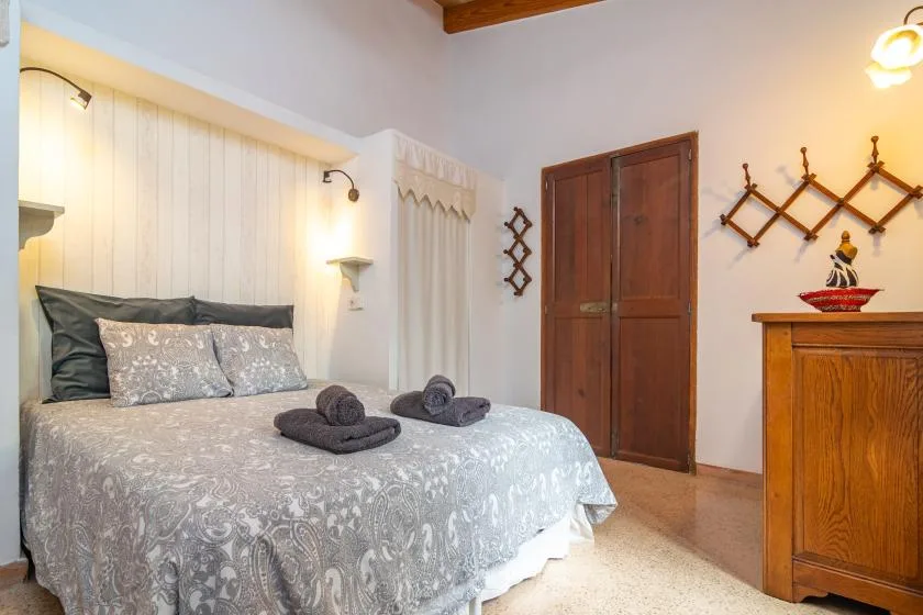 A bedroom with a neatly made bed and a wooden door.