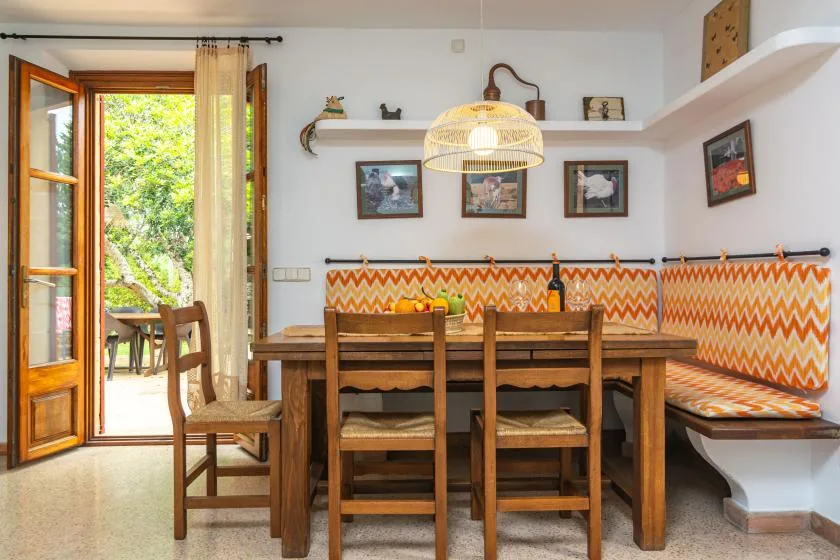 A dining area with a wooden table, chairs, and a built-in bench.