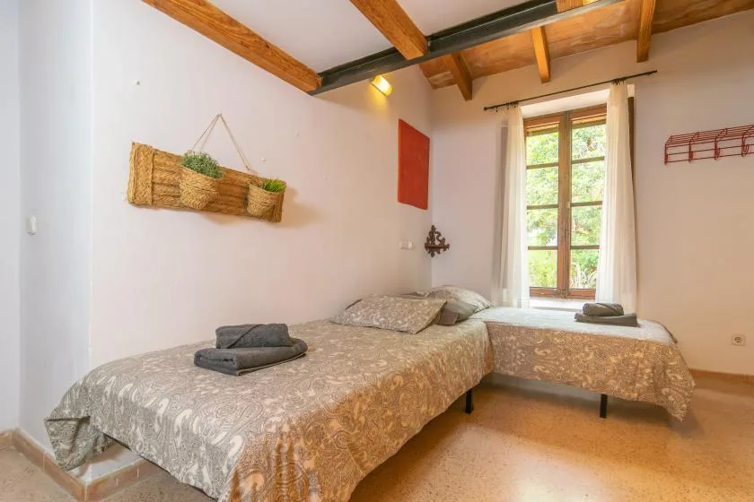A bedroom with two beds and a window.