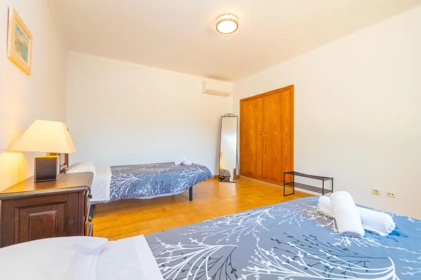Un dormitorio con camas, una puerta de madera y una mesita de noche.