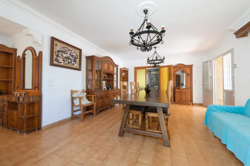 Una sala de estar amplia con muebles de madera y una mesa en el centro.
