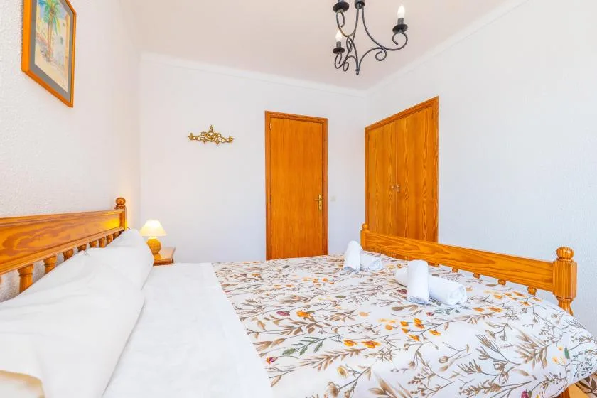 Un dormitorio con una colcha floral y puertas de madera.