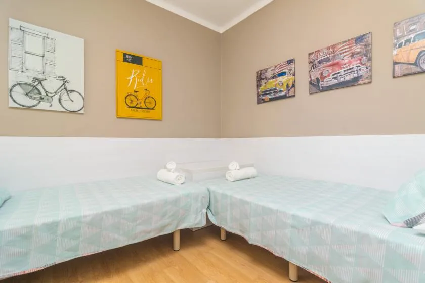 A bedroom with two beds and bicycle-themed artwork on the walls.