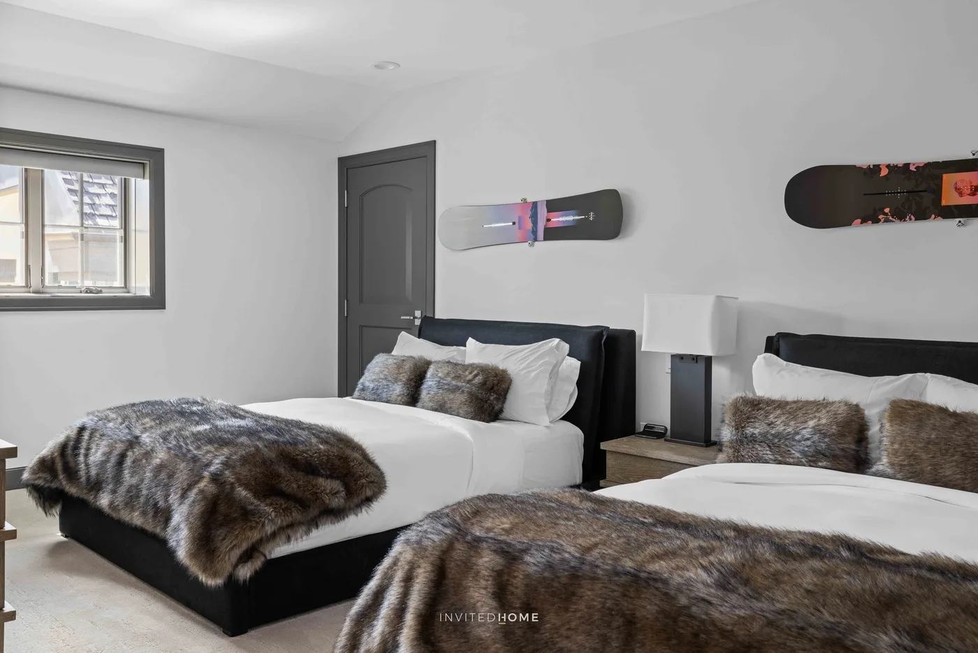 Un dormitorio con dos camas, cabeceros oscuros y tablas montadas en la pared.