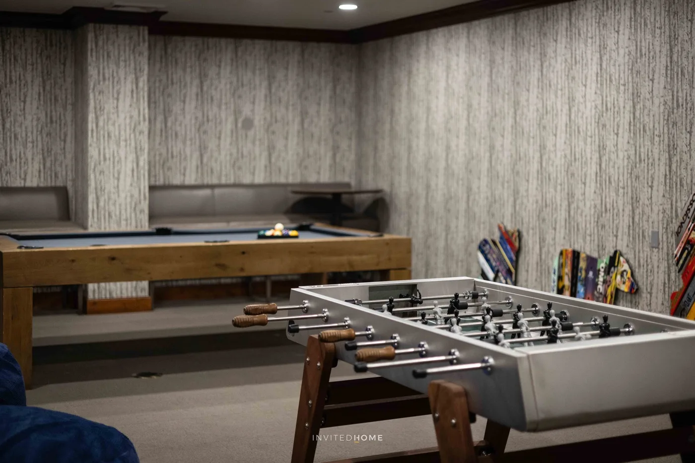 Una sala de juegos con una mesa de billar y un futbolín.
