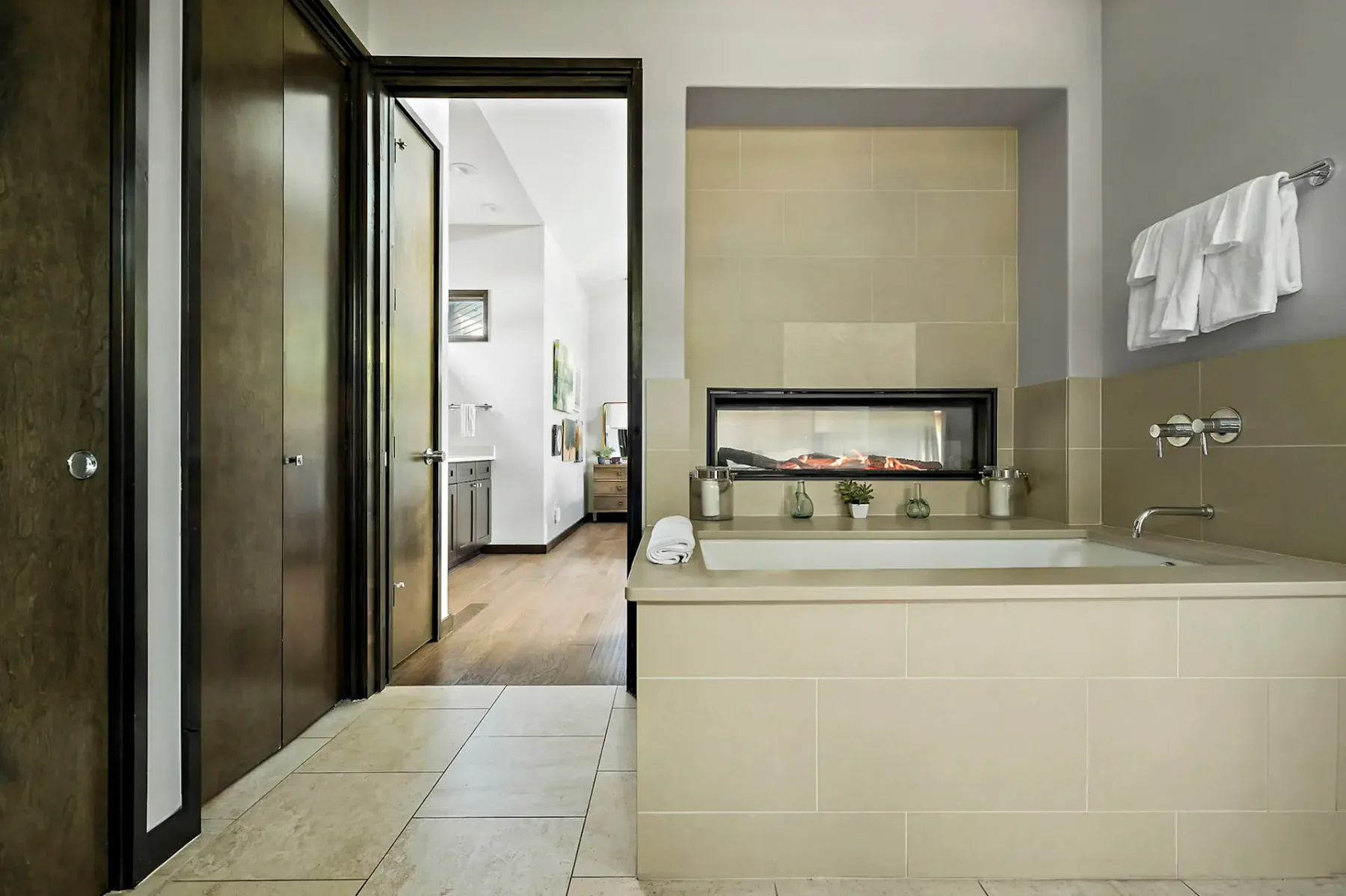 Un baño con azulejos, una bañera y una chimenea visible detrás.