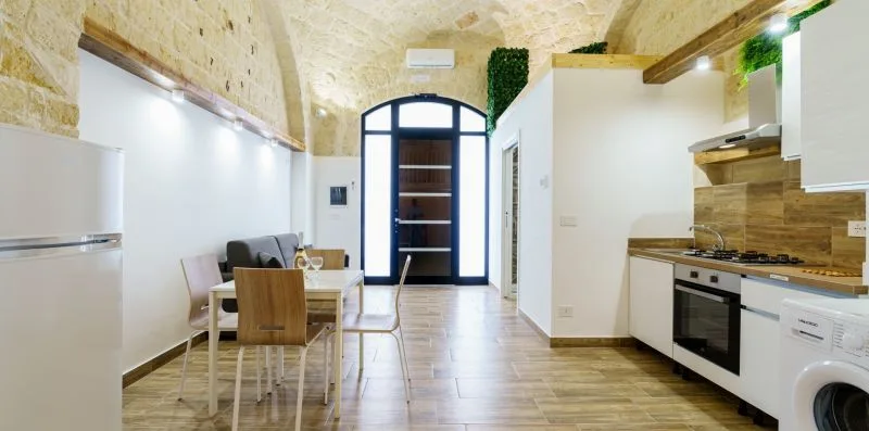 A bright kitchen and dining area with a table beside the cooking counter.