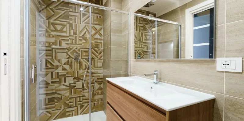 A modern bathroom with a glass shower and a long vanity.