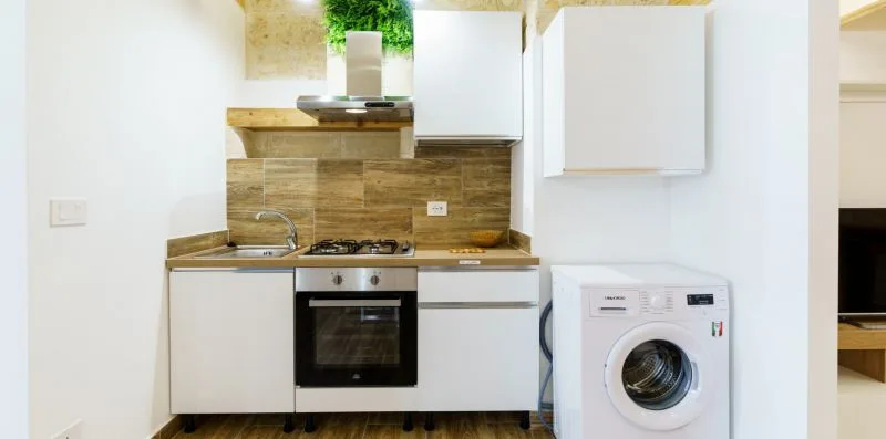 A compact kitchen with a stove, oven, and washing machine.