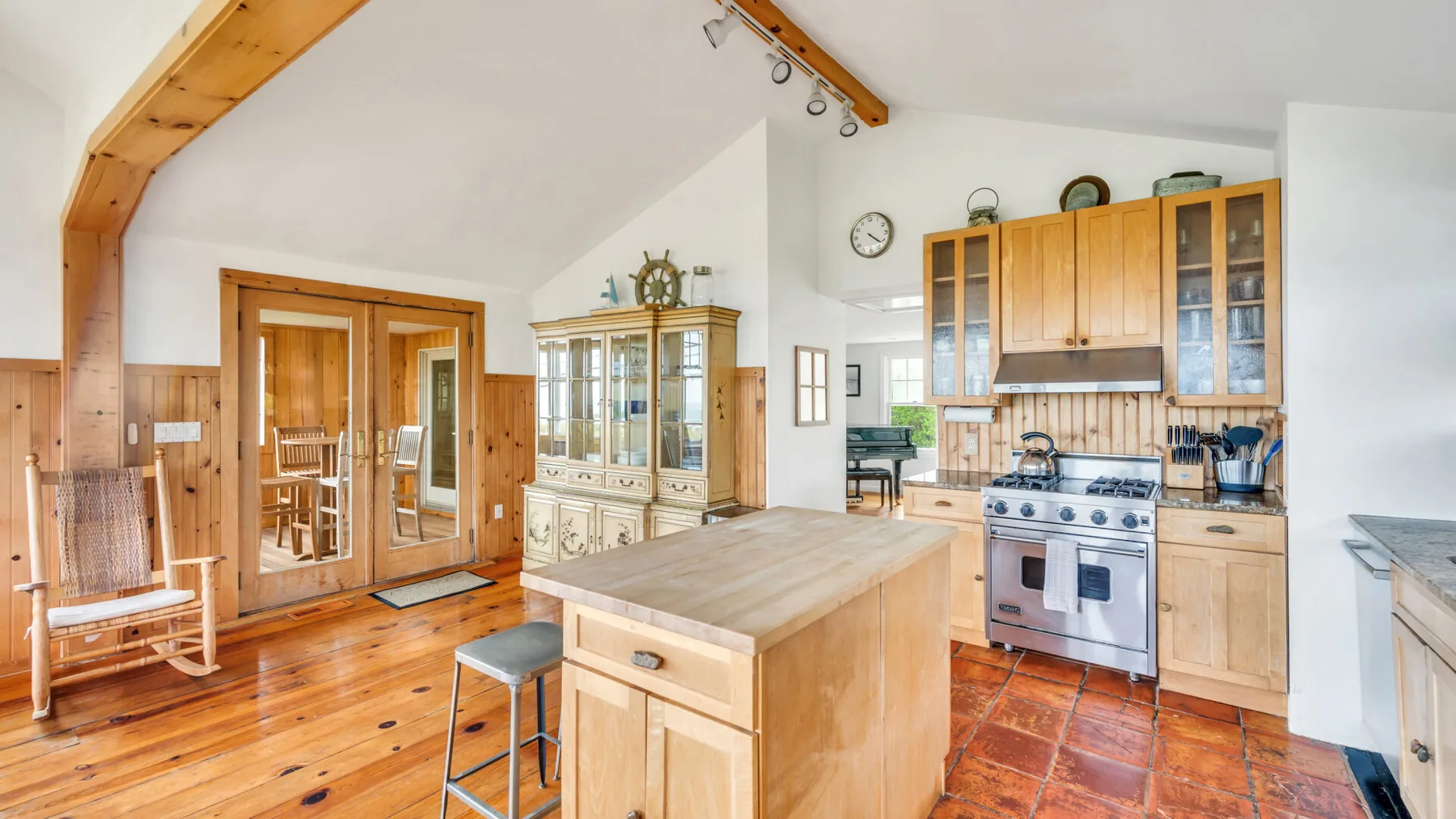 Una cocina y comedor luminosos con gabinetes de madera e isla central.