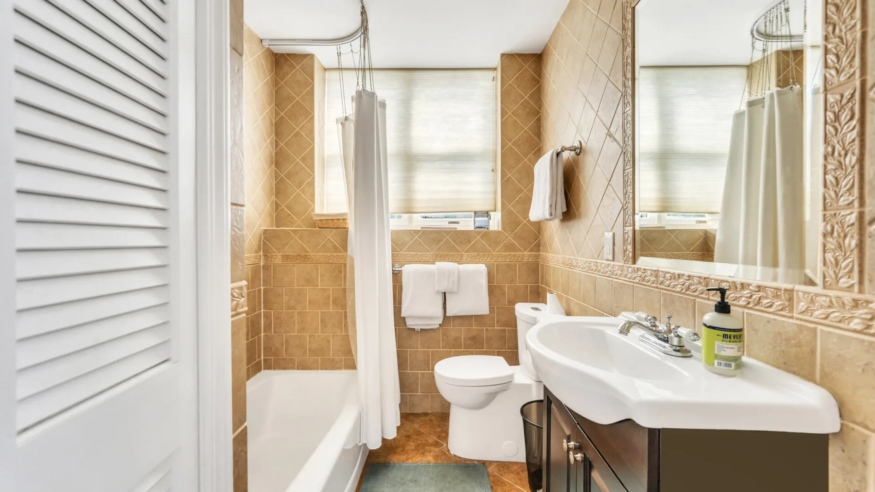 Un baño con bañera, cortina de ducha, inodoro y lavabo.