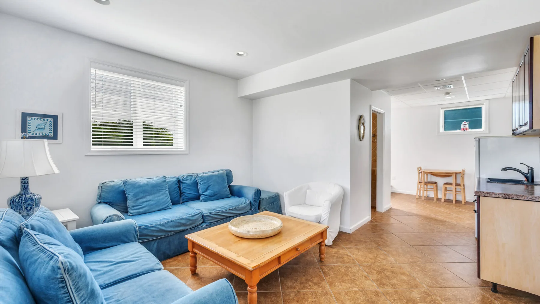 Una sala luminosa con asientos azules y una mesa de centro de madera.