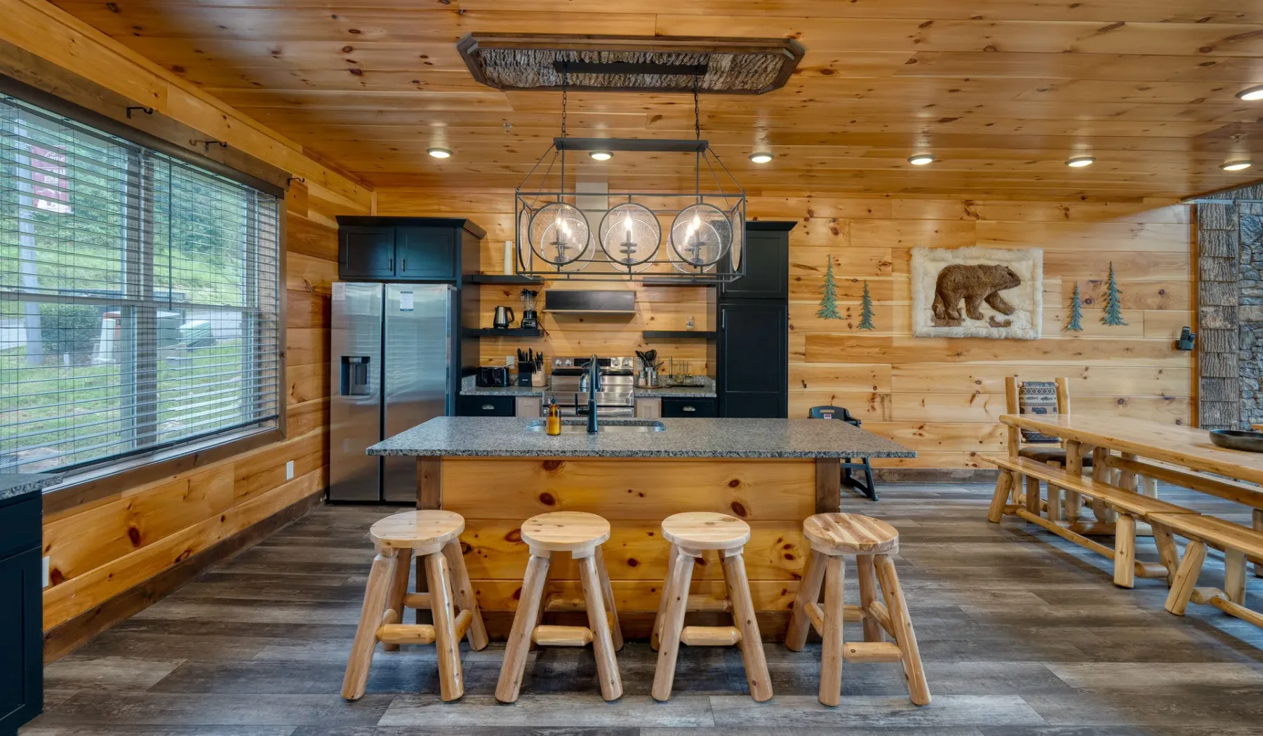 Una cocina revestida de madera con una isla y taburetes.