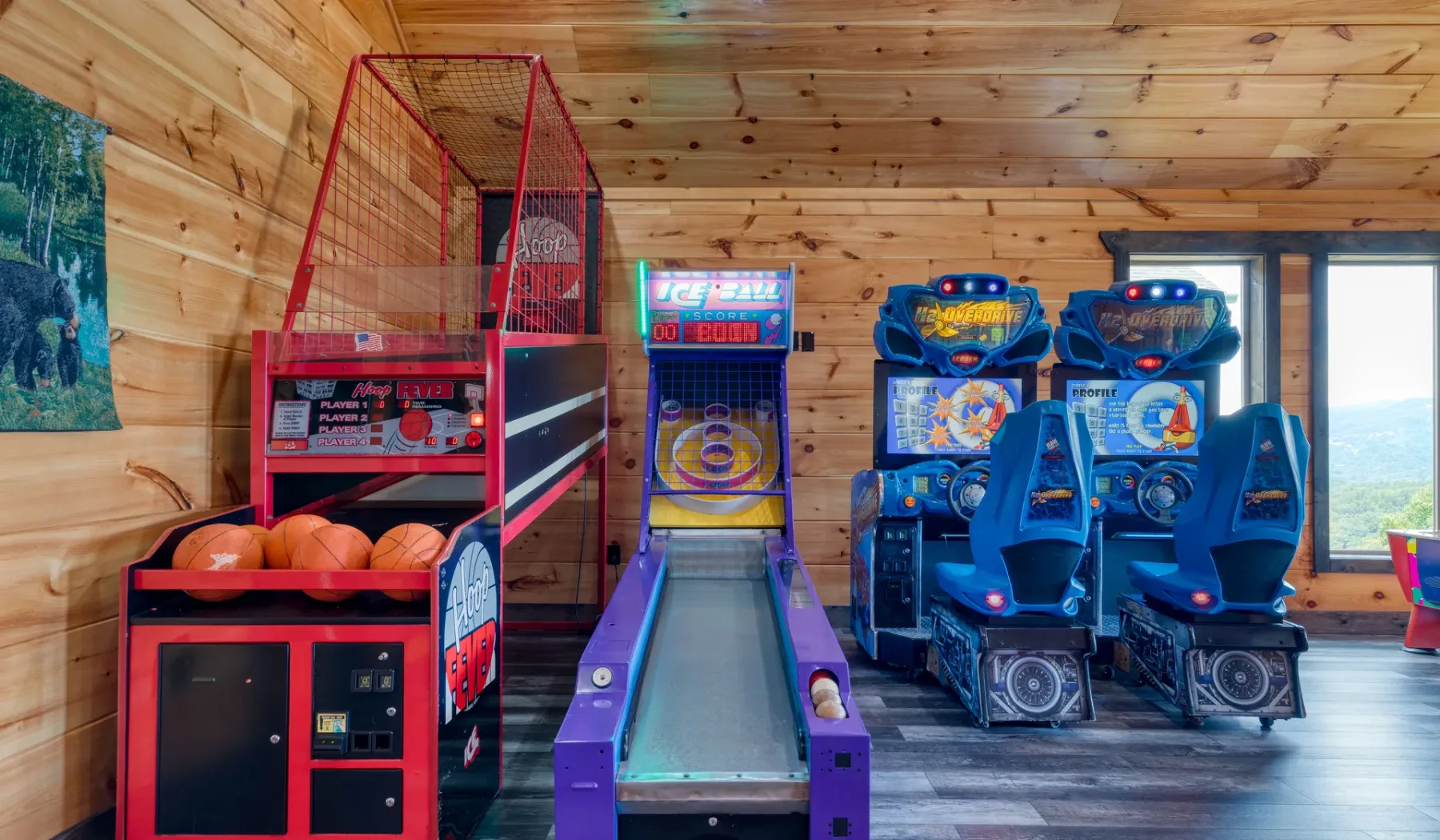 Una sala de juegos con un juego de baloncesto, una pista de skee-ball y juegos de carreras.