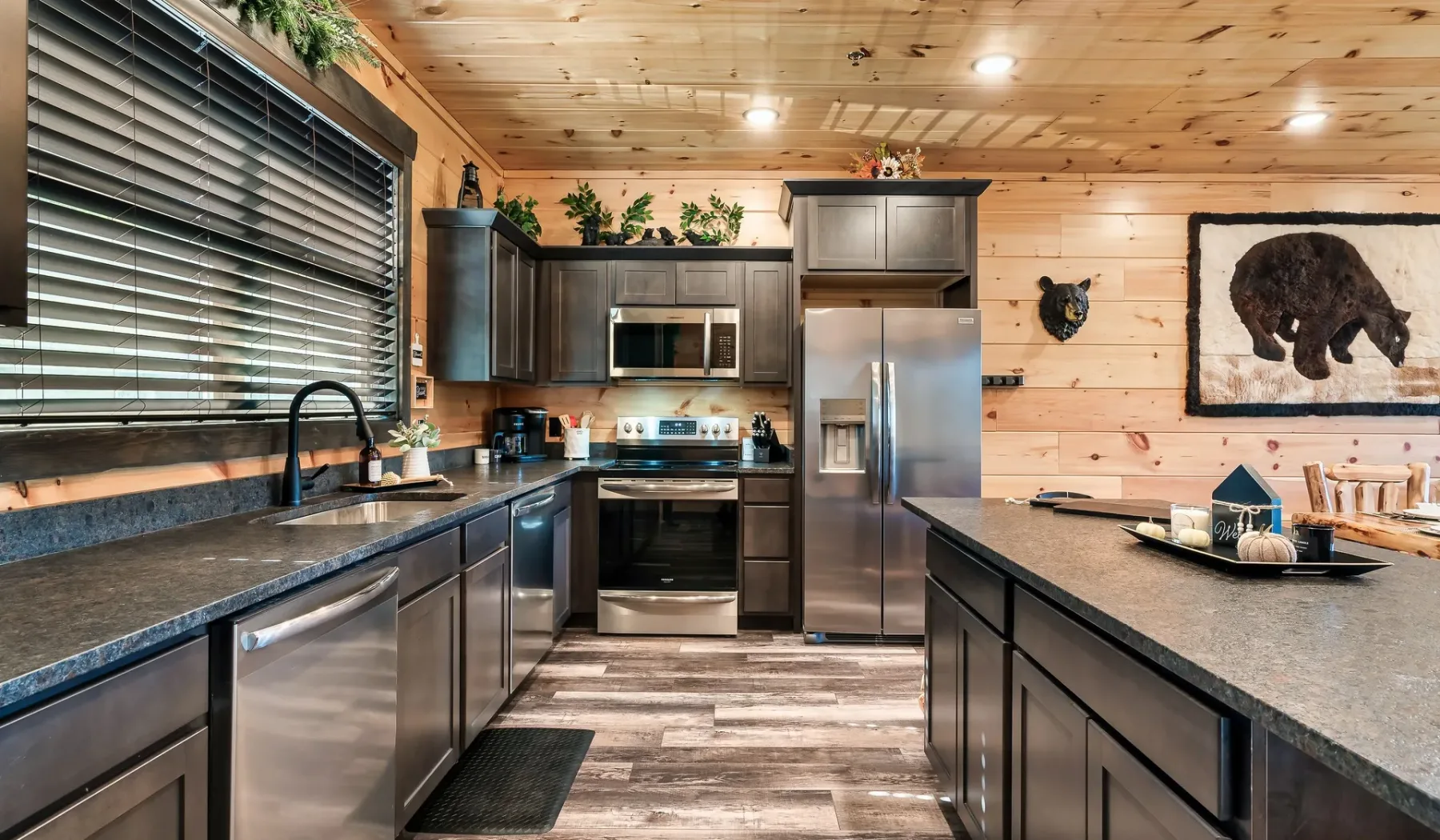 Una cocina revestida de madera con gabinetes oscuros, electrodomésticos de acero inoxidable e isla central.
