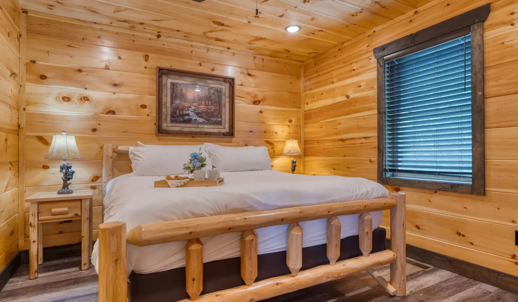Un dormitorio con una cama bien tendida y paredes revestidas de madera.
