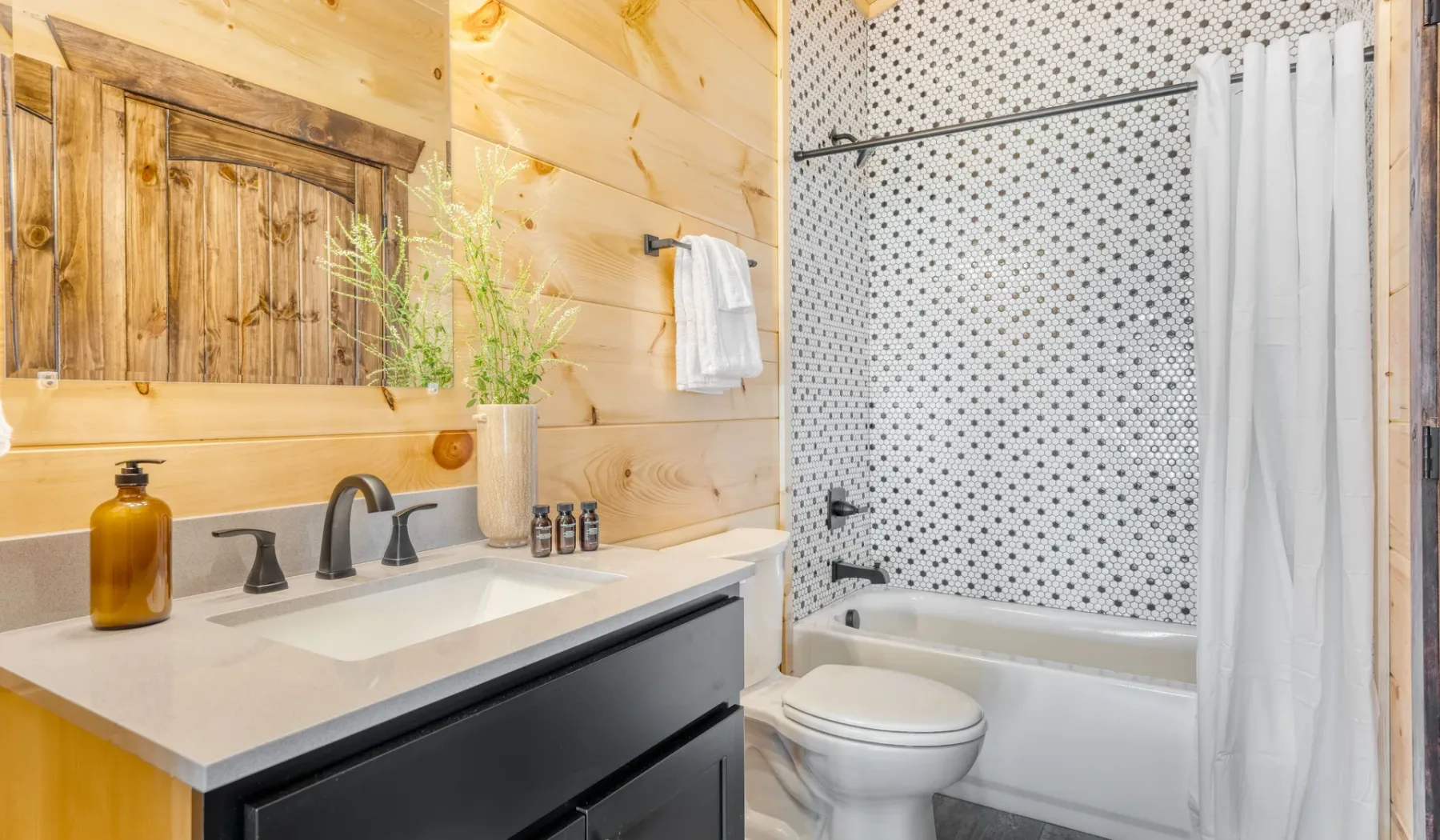 Un baño con lavabo, inodoro y bañera con cortina de ducha.