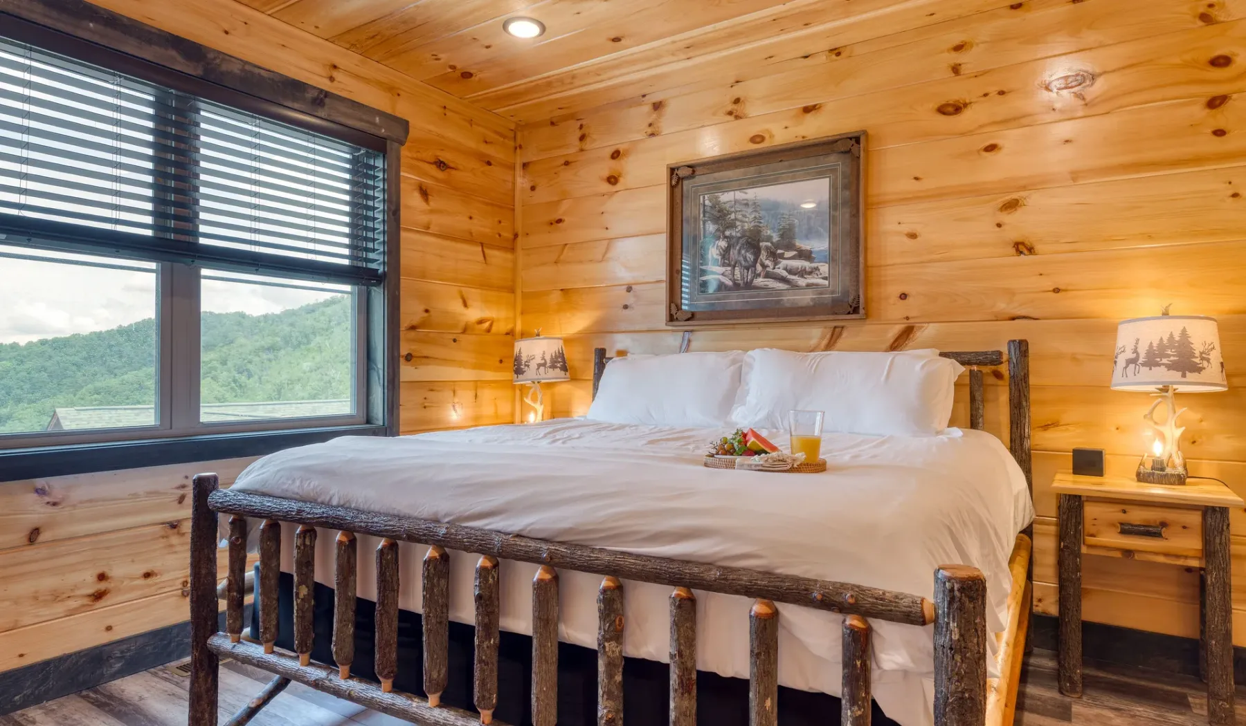 Un dormitorio con una cama grande bajo un cuadro, rodeado de paredes revestidas de madera.
