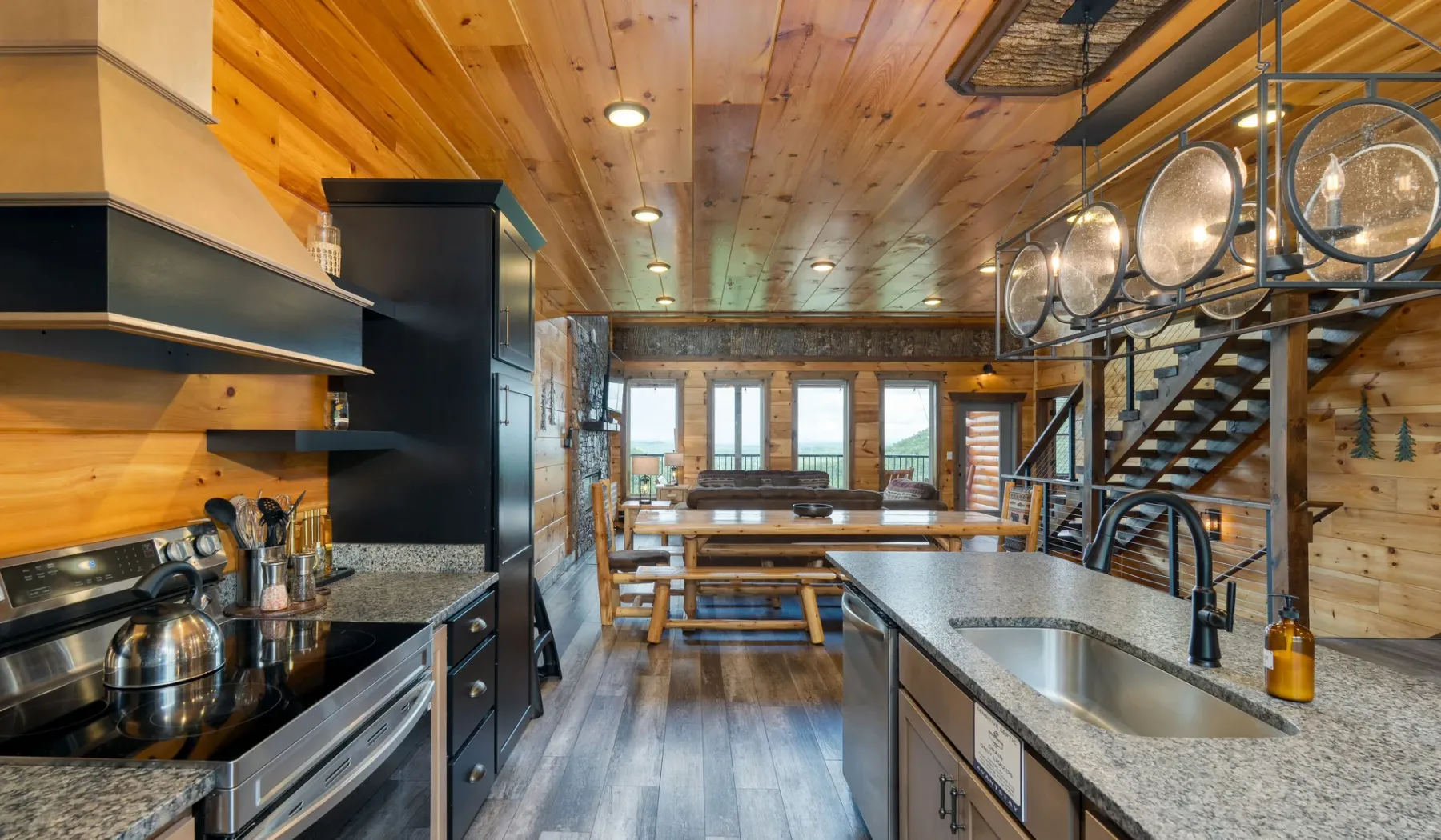Cocina revestida de madera con una isla central, fregadero y electrodomésticos de acero inoxidable.