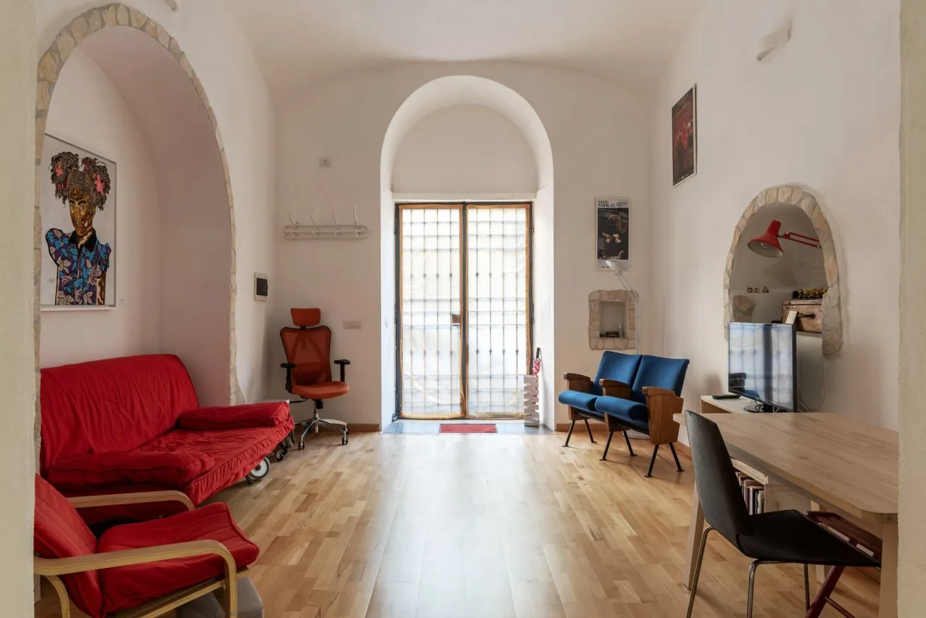 Una sala luminosa con asientos rojos y altos arcos.