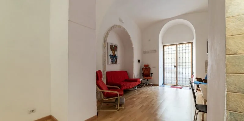 A living room with red seating and a bright glass door.