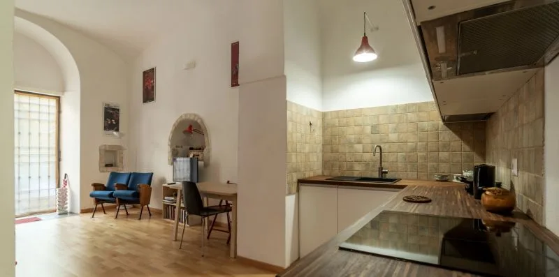 Una estancia diáfana combina una pequeña zona de estar con una cocina.