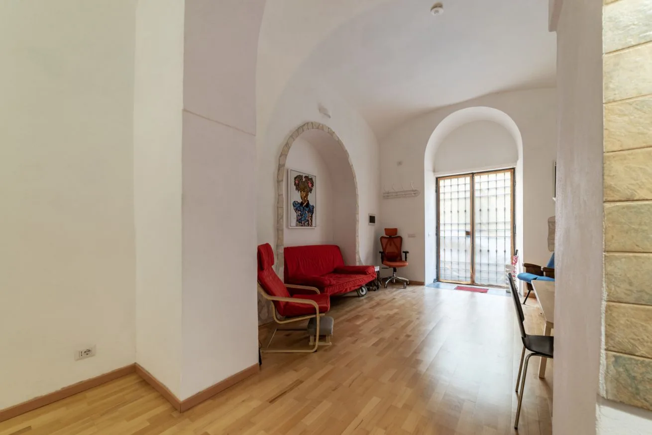 Una sala luminosa con asientos rojos y una puerta de cristal al fondo.