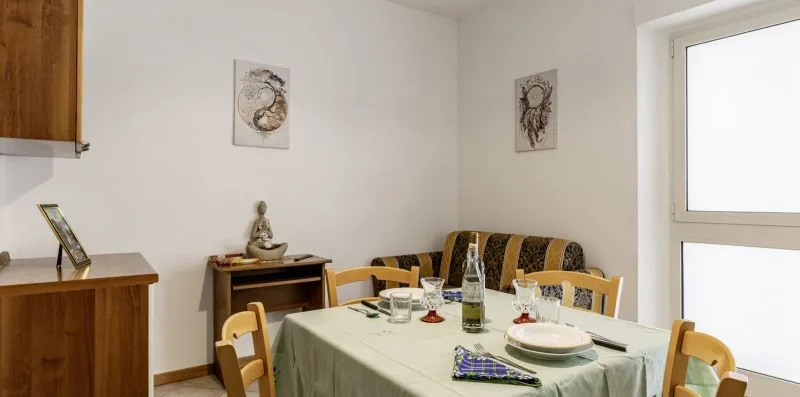 Un comedor con una mesa puesta para comer y asientos.