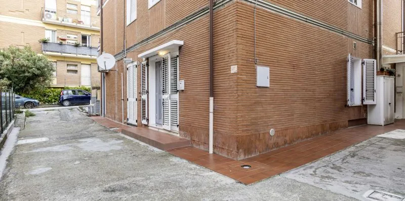 A brick building exterior borders a paved courtyard.